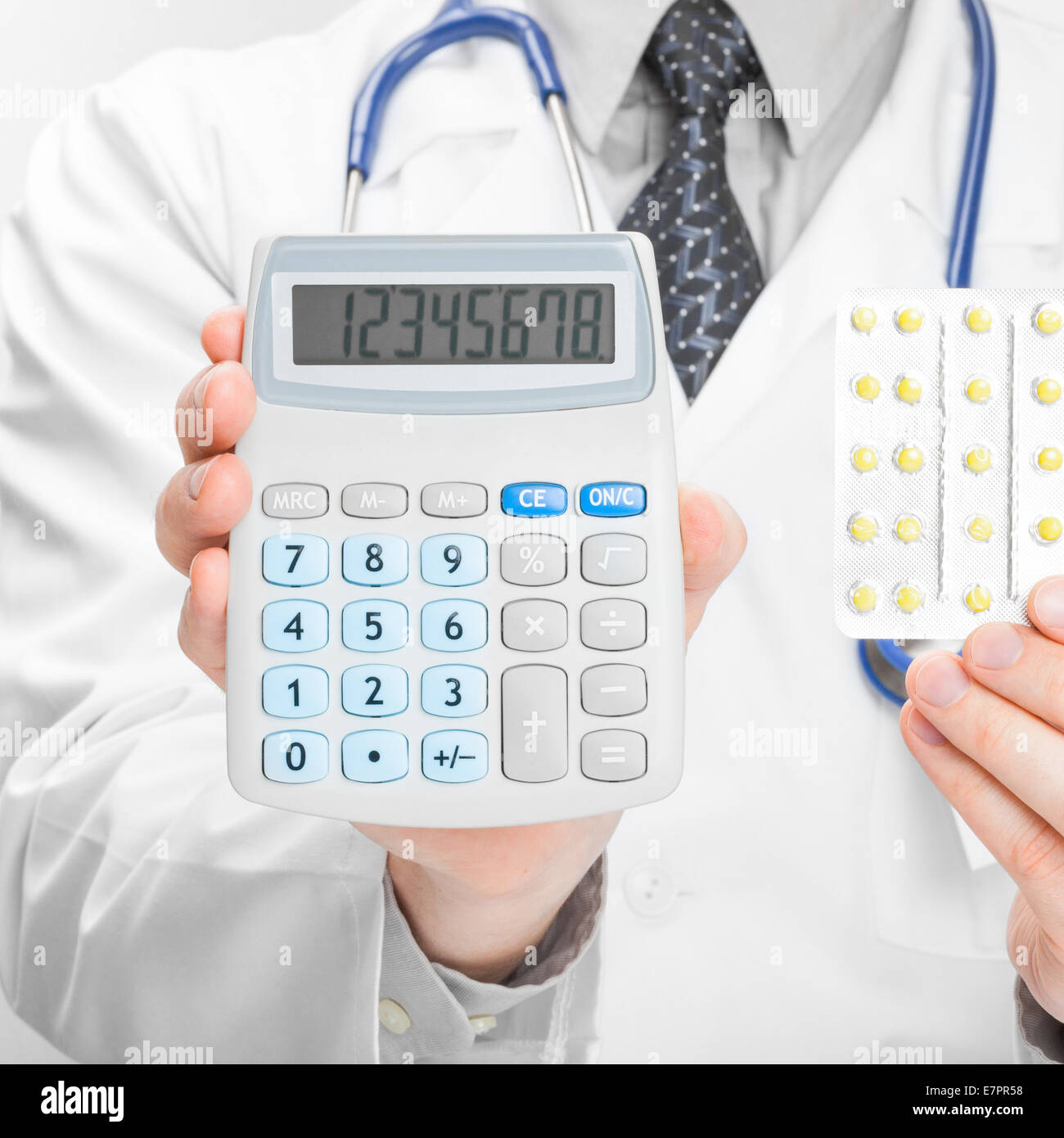 Medical doctor holding calculator and pills in his hands - 1 to 1 ratio ...
