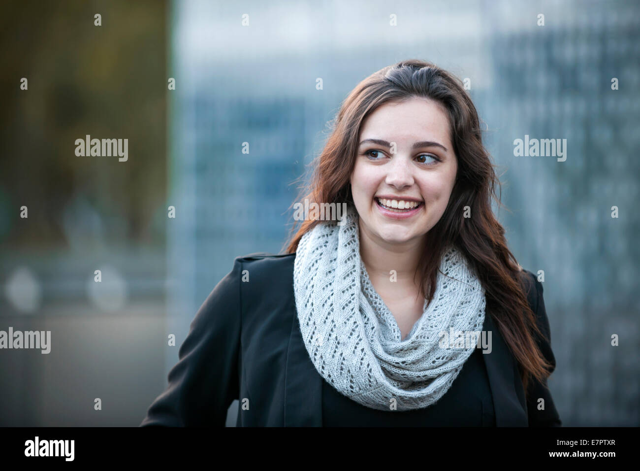 Candid portrait of young brunette woman smiling and looking to side with copy space Stock Photo