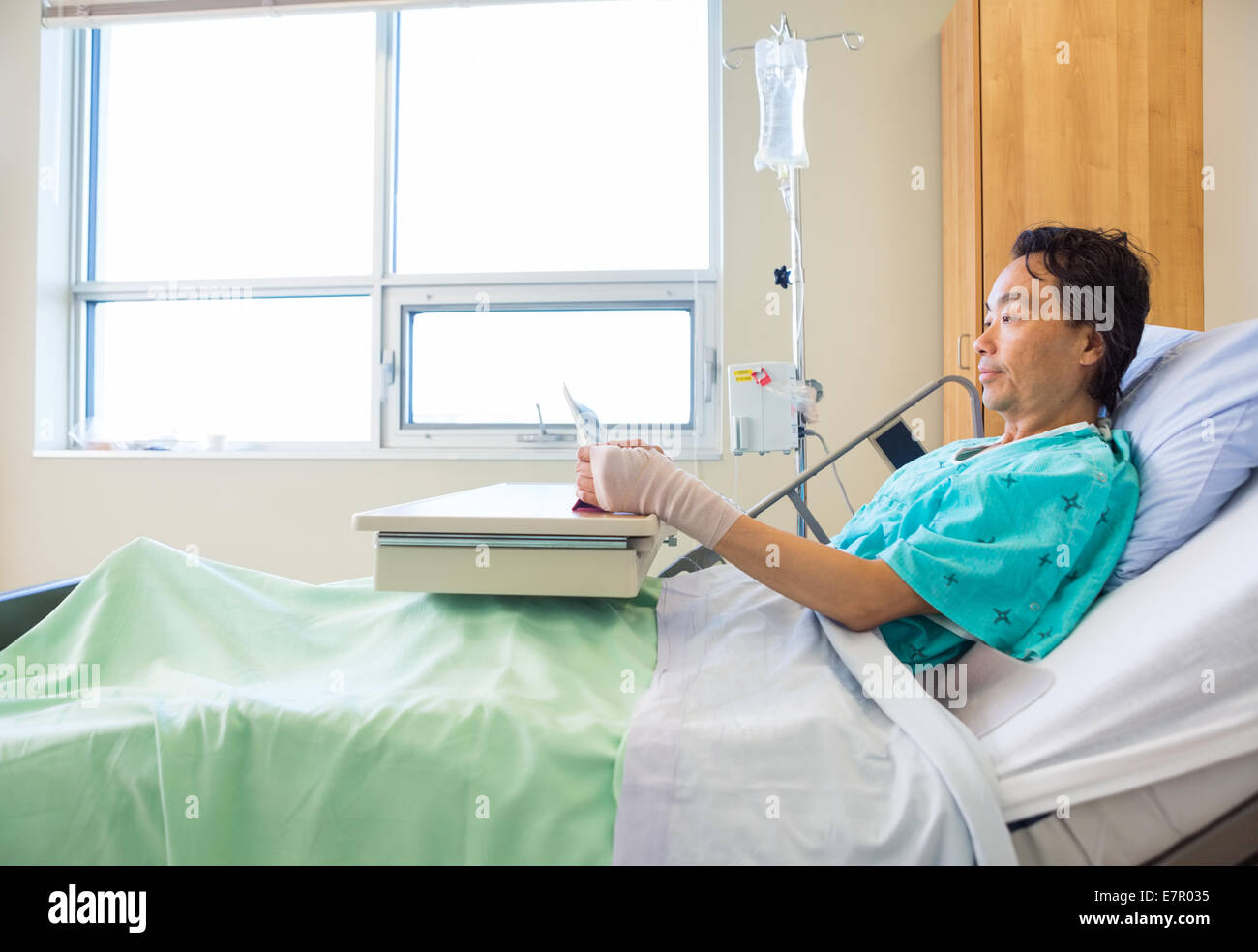 Patient Using Digital Tablet On Hospital Bed Stock Photo