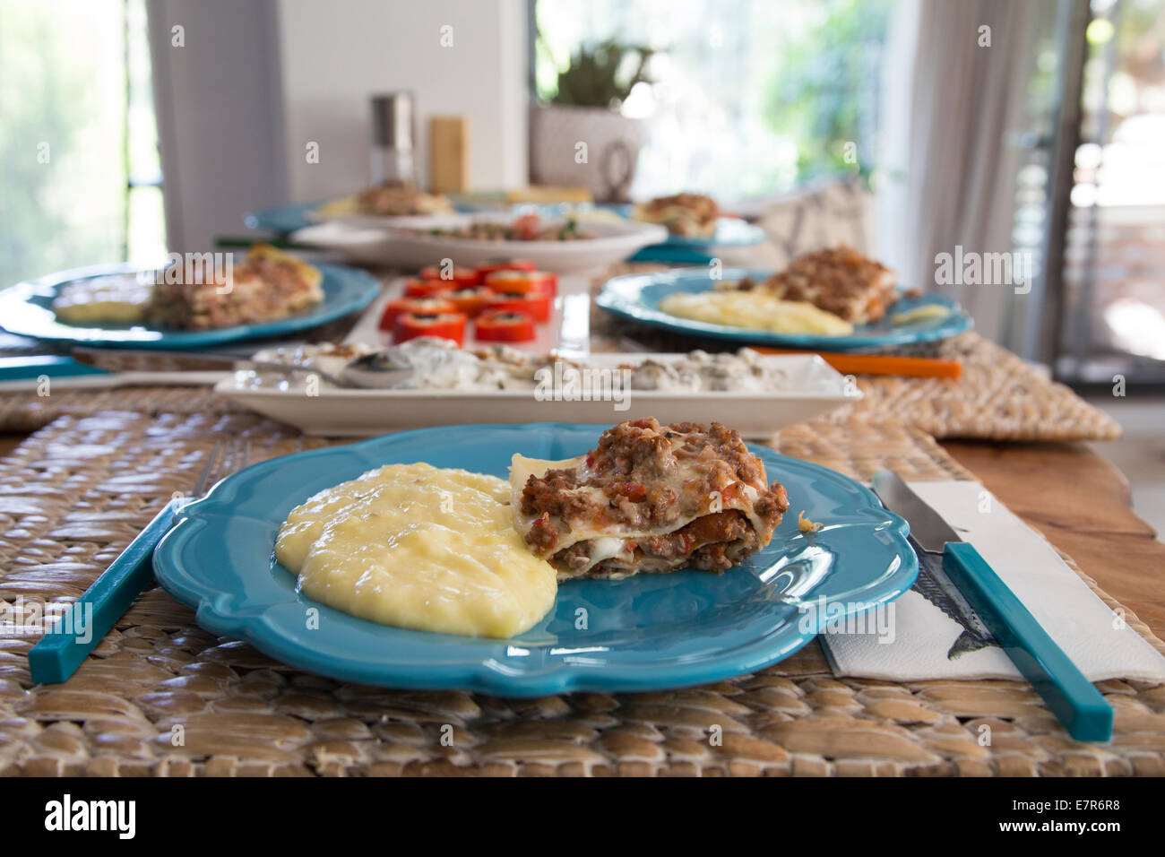 Homemade Lasagna and Mashed Potatoes in a Plate on the Dining Table Stock Photo