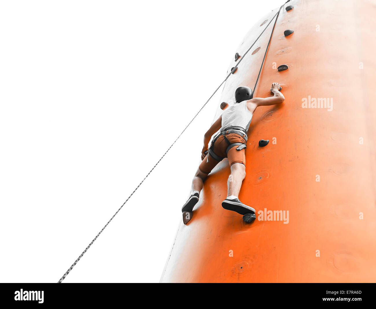 Young man climbing on an artificial wall Stock Photo