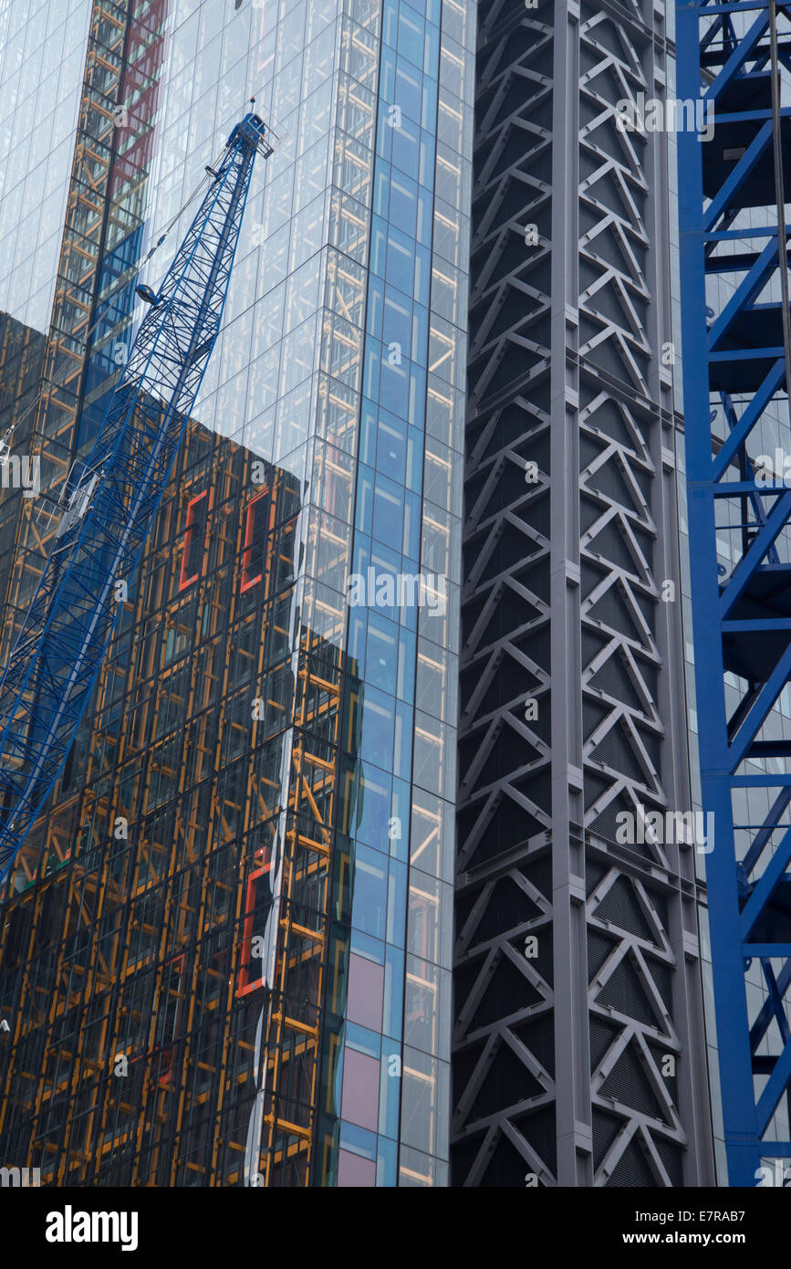 Building construction with blue cranes and reflections in Gracechurch Street, City of London, England Stock Photo