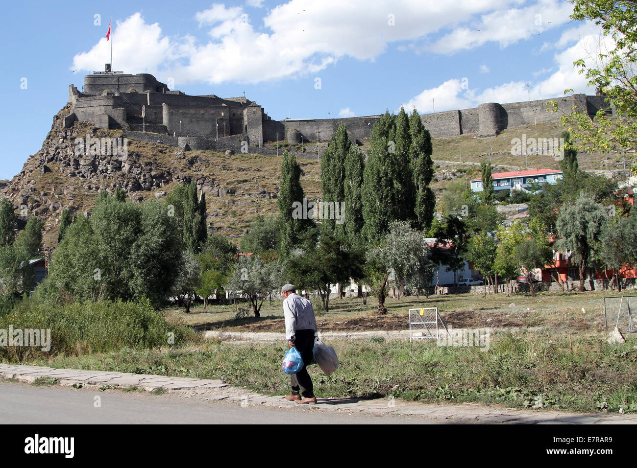 A man walks past Kars Fortress, which overlooks the town of Kars, in eastern Turkey. Stock Photo