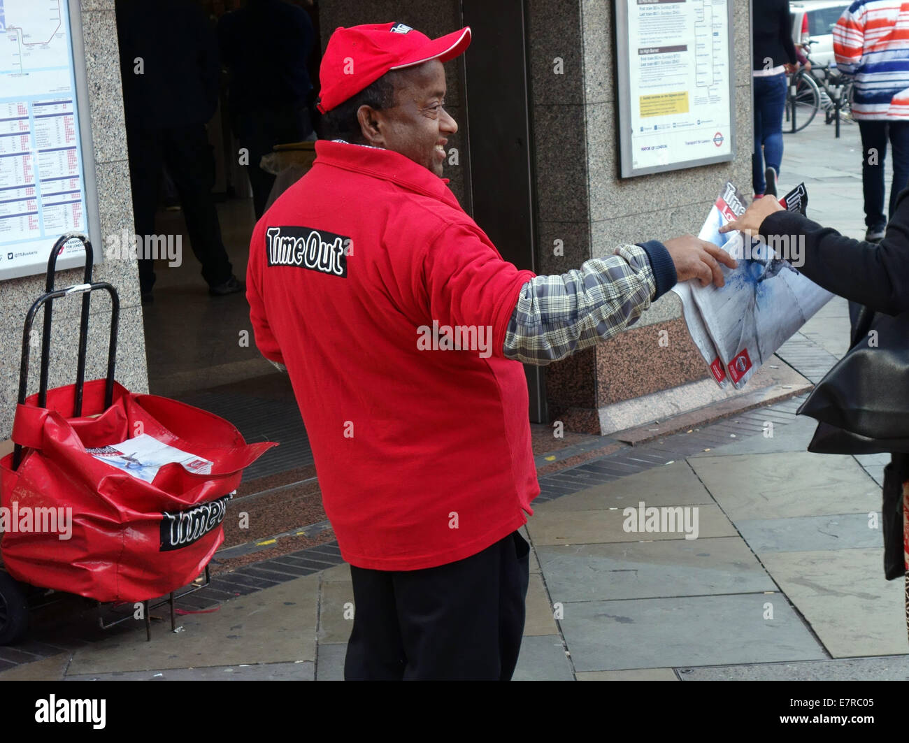 Time Out magazine distributor outside London underground station Stock