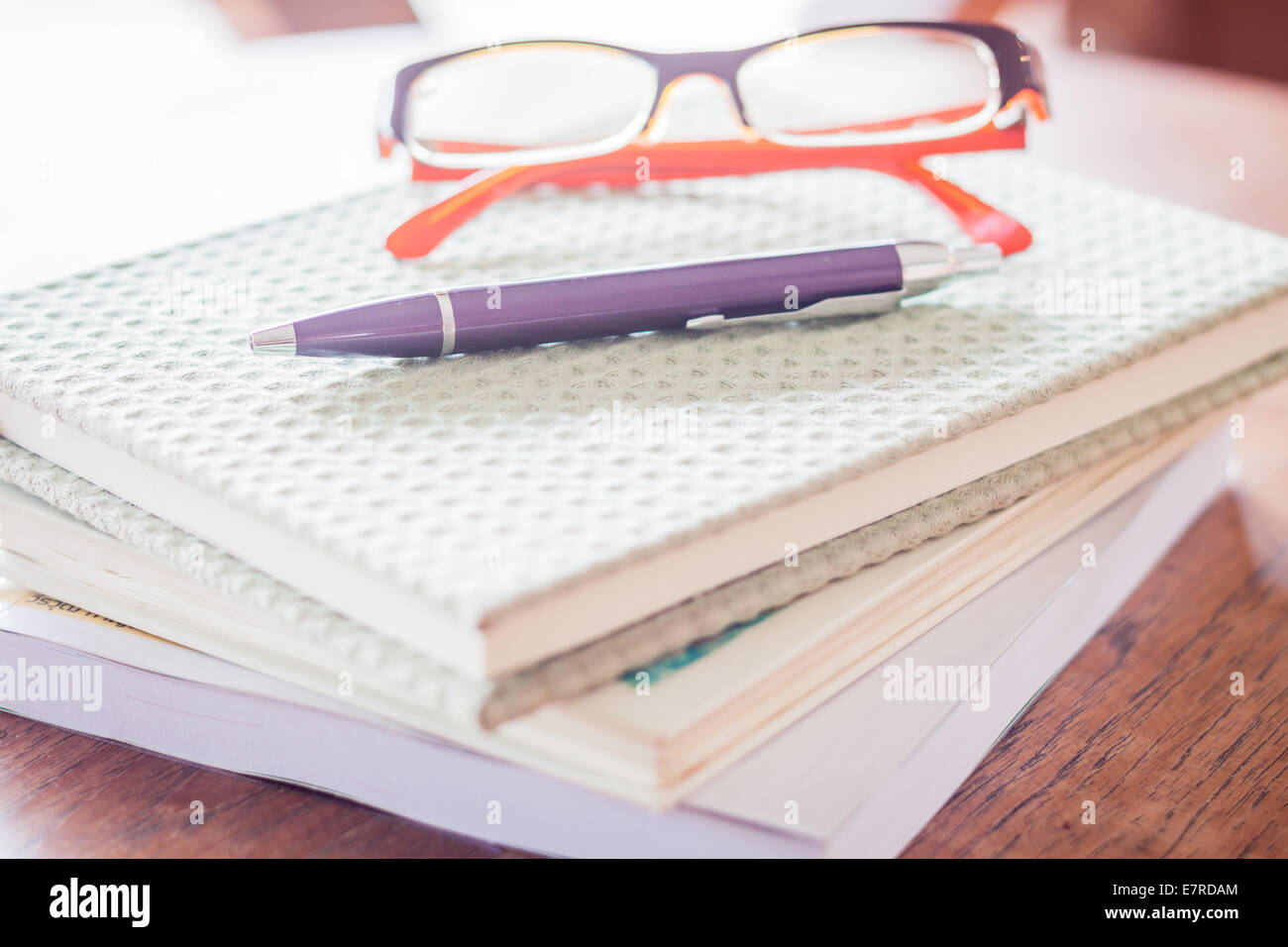 Pen and eyeglasses on three notebooks, stock photo Stock Photo