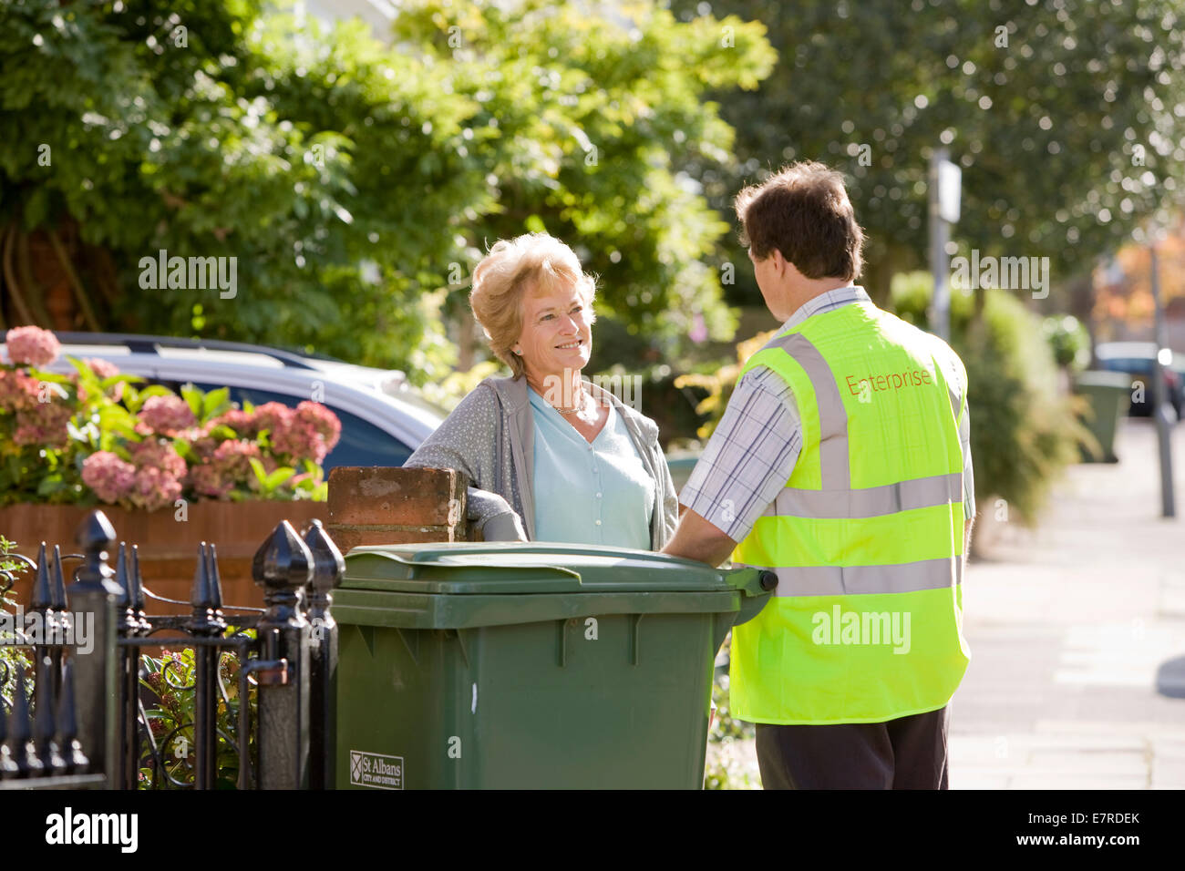 Woman talking to a council recycling man in the street about recycling household waste Stock Photo