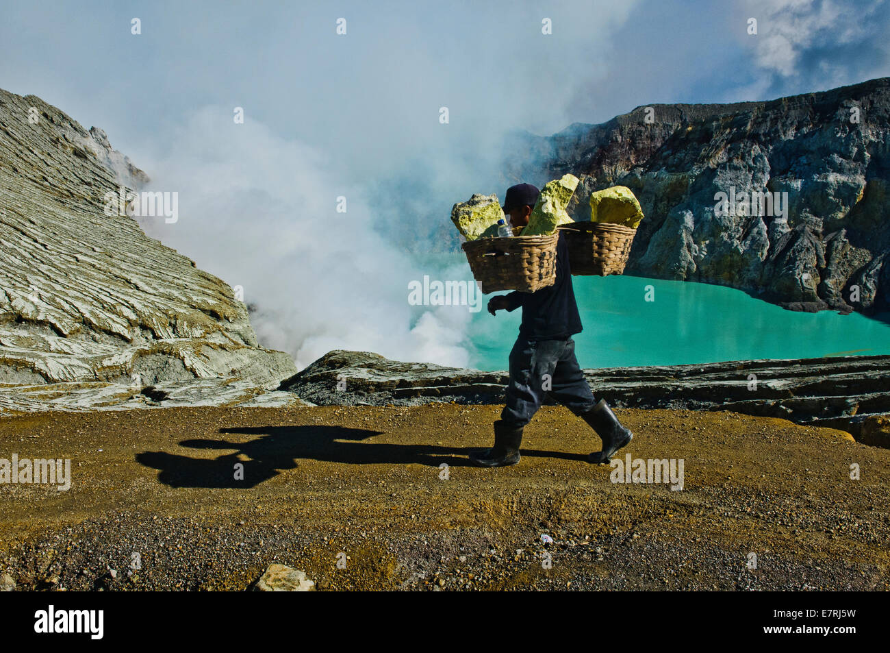Sulphur miner carrying a load of sulphur at the Kawah Ijen crater Stock ...