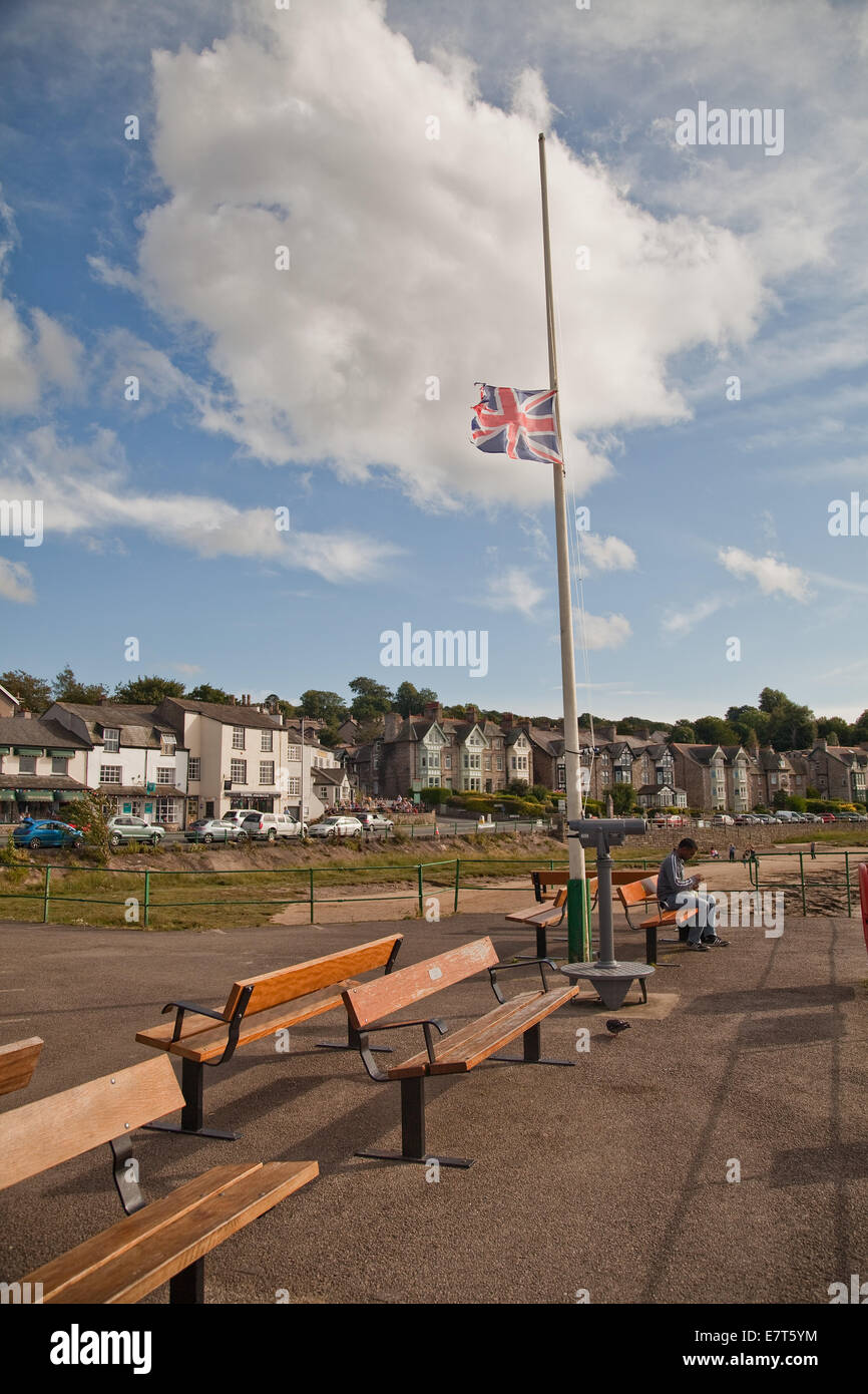 Arnside on the Cumbrian coast,a flag flutters at half mast, for no apparent reason.Fluffy white clouds shoot across a blue sky. Stock Photo