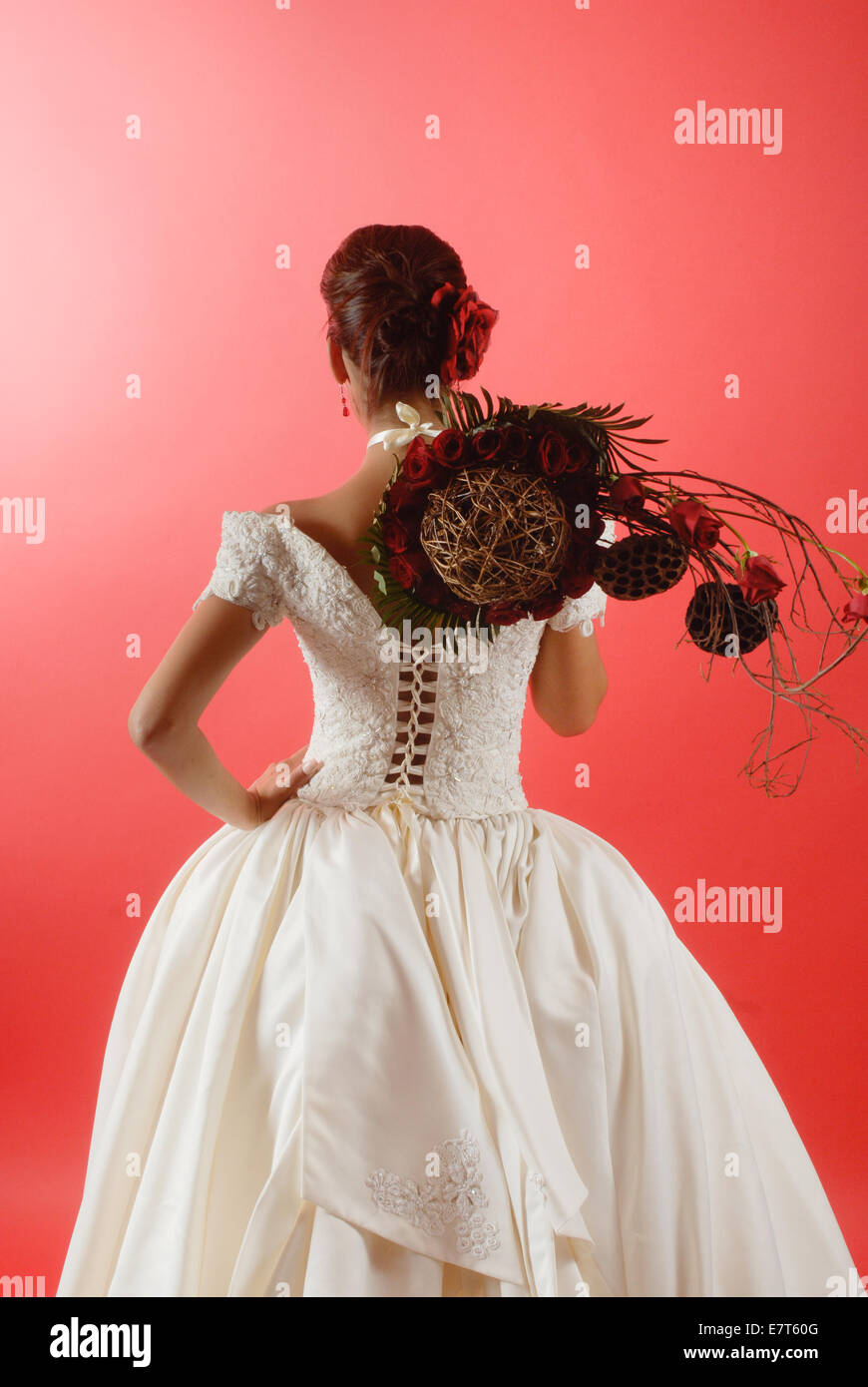 a bride with flowers over a red background Stock Photo - Alamy