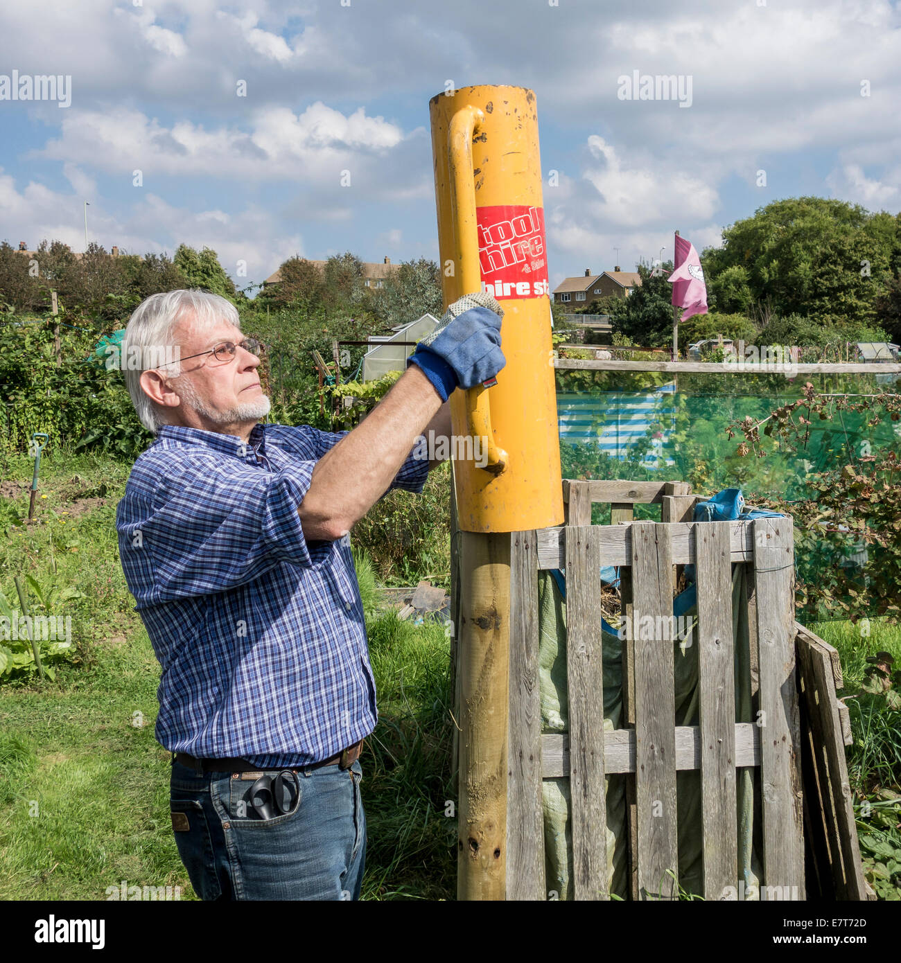 Man using Fence Post Hammer on Allotment Stock Photo