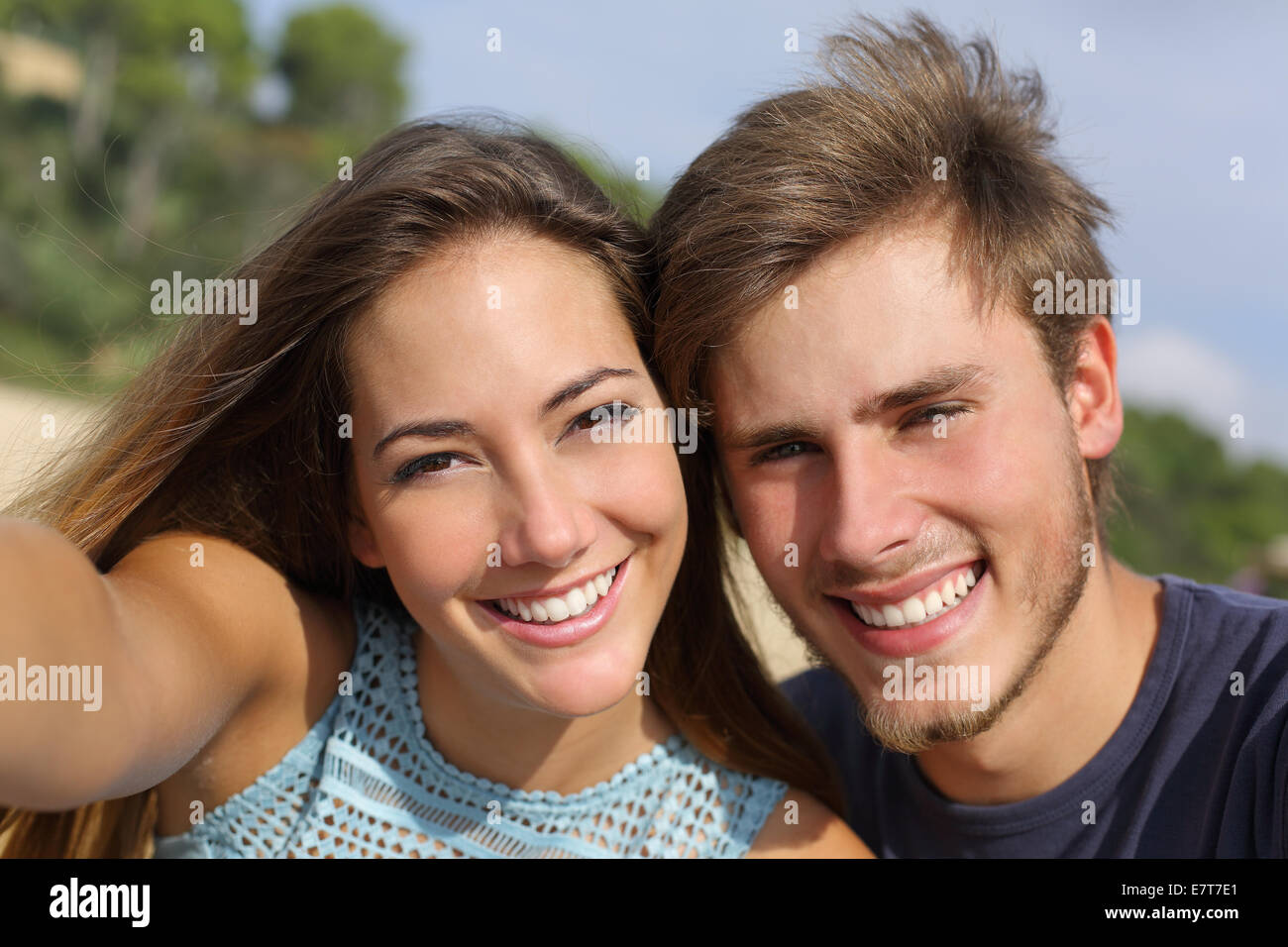 Couple photographing a selfie with the smart phone or digital camera outdoors in the mountain Stock Photo