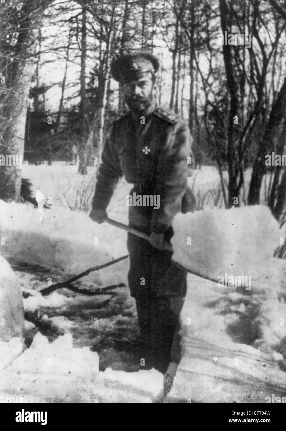 Title: Emperor Nicholas II shovelling snow in the park at Tsarskoe Selo, Russia, where he and the royal family were interned, 1917 Stock Photo