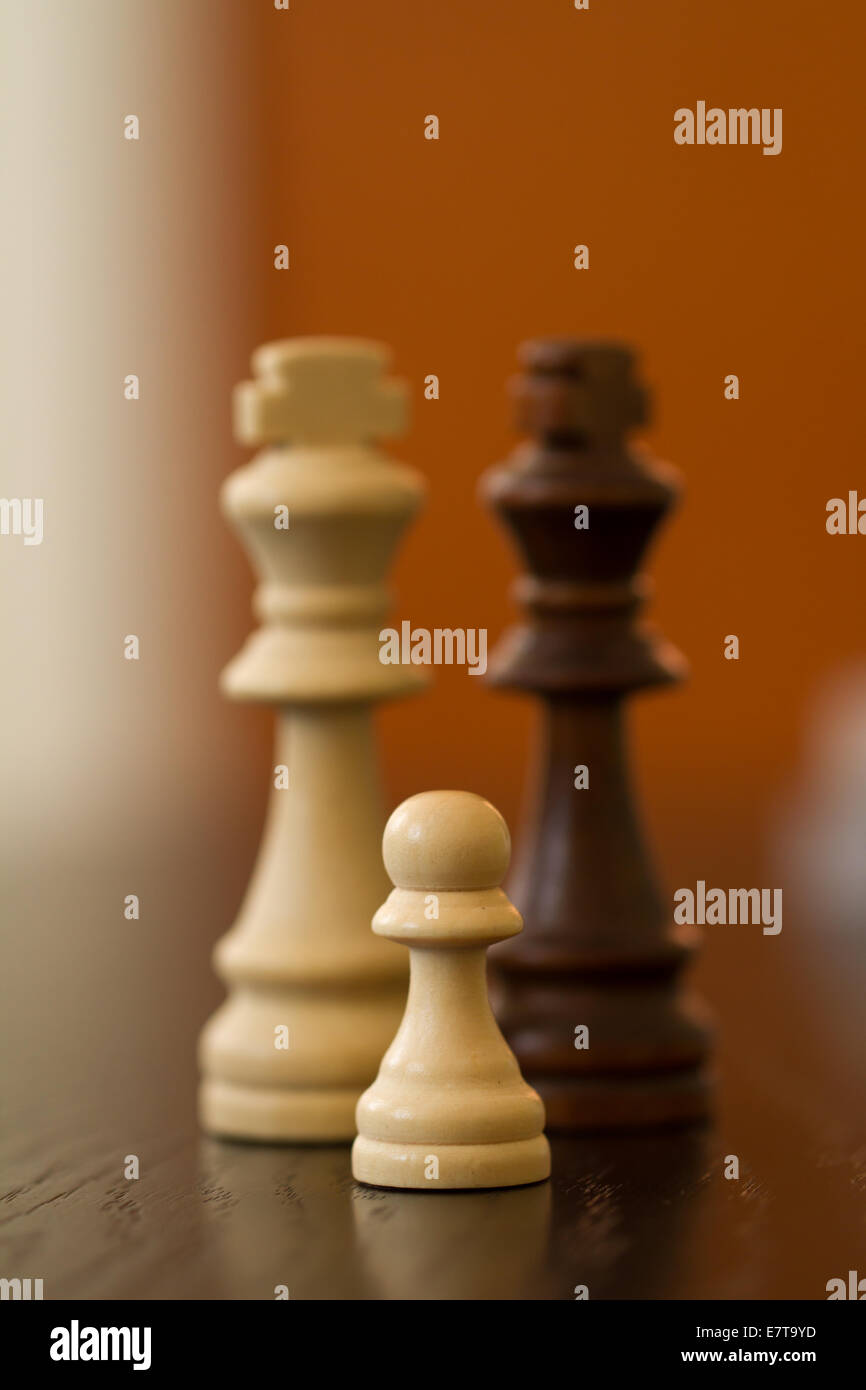 Family concept with chess pieces, kings and a pawn on wooden table. Stock Photo