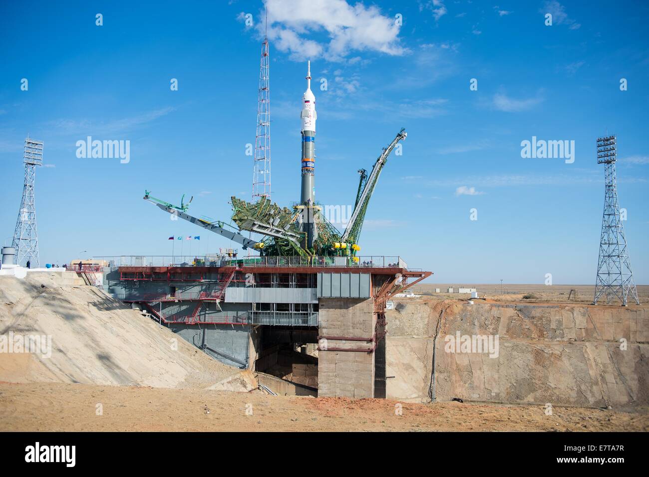 The gantry arms begin to close around the Soyuz TMA-14M spacecraft after being lifted into position on the launch pad at the Baikonur Cosmodrome September 23, 2014 in Kazakhstan. Launch of the Soyuz rocket is scheduled for Sept. 26 and will carry Expedition 41 crew to the International Space Station for a five and a half month mission. Stock Photo