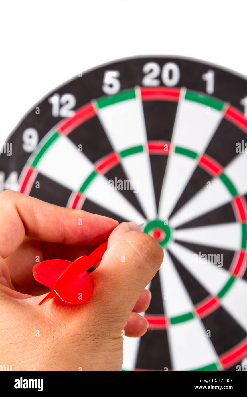 Hand holding plastic, red arrow and throwing to dart board, isolated on