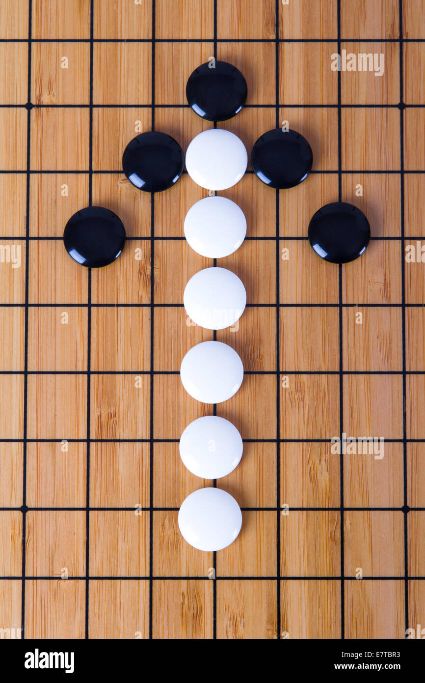 Top view of black and white Chinese go game pieces, up direction arrow
