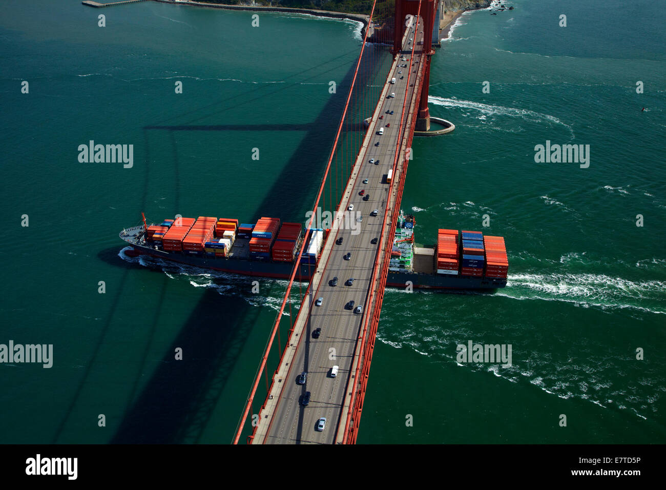 Container ship passing under traffic on Golden Gate Bridge, San Francisco Bay, San Francisco, California, USA - aerial Stock Photo