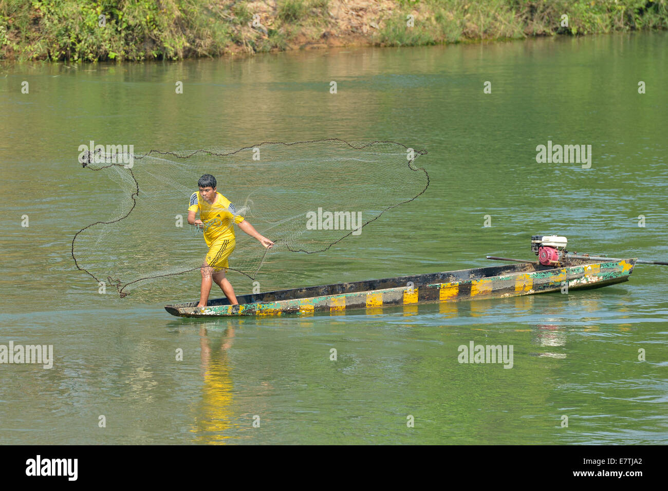 Don Det, Laos - March 13, 2014: Man fishing with a net in the Mekong river in Don Det, Laos. Stock Photo