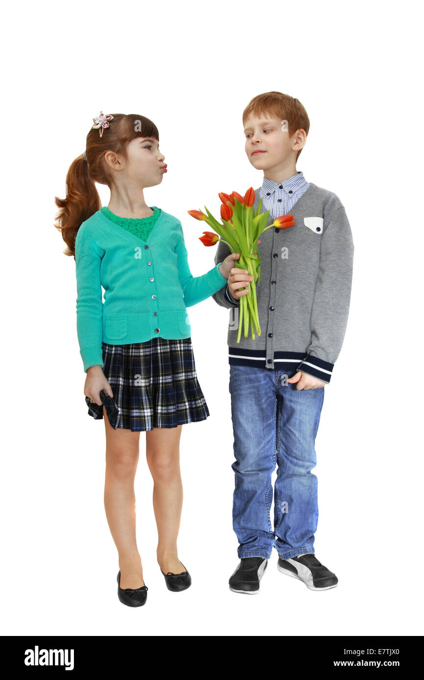 Girl and boy stand together and hold bouquet of flowers in hands. Girl is going to kiss. Isolated on white background Stock Photo