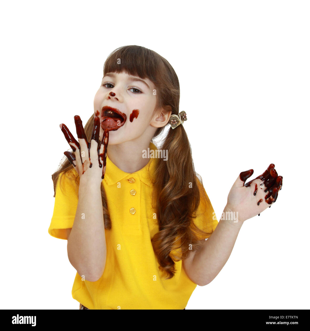 Girl soiled in chocolate licks fingers isolated on white background Stock Photo