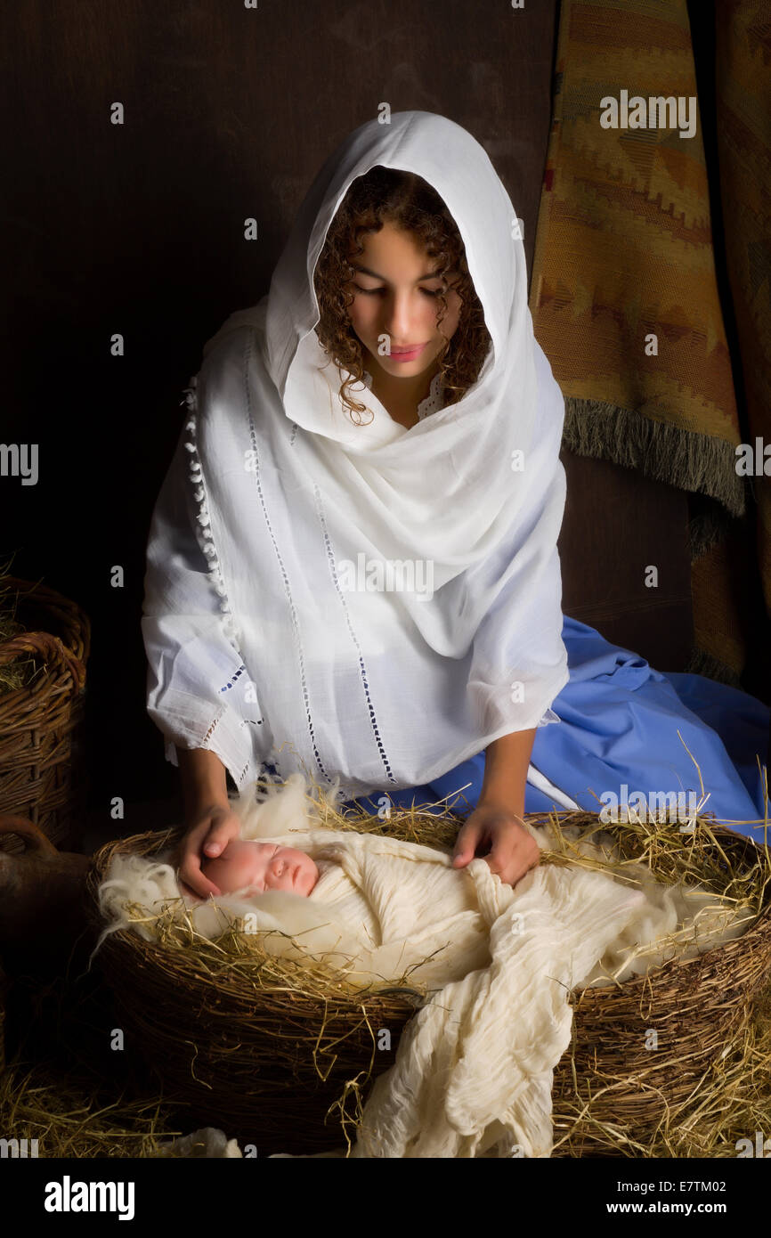 Teenager girl playing the role of the Virgin Mary with a doll in a live