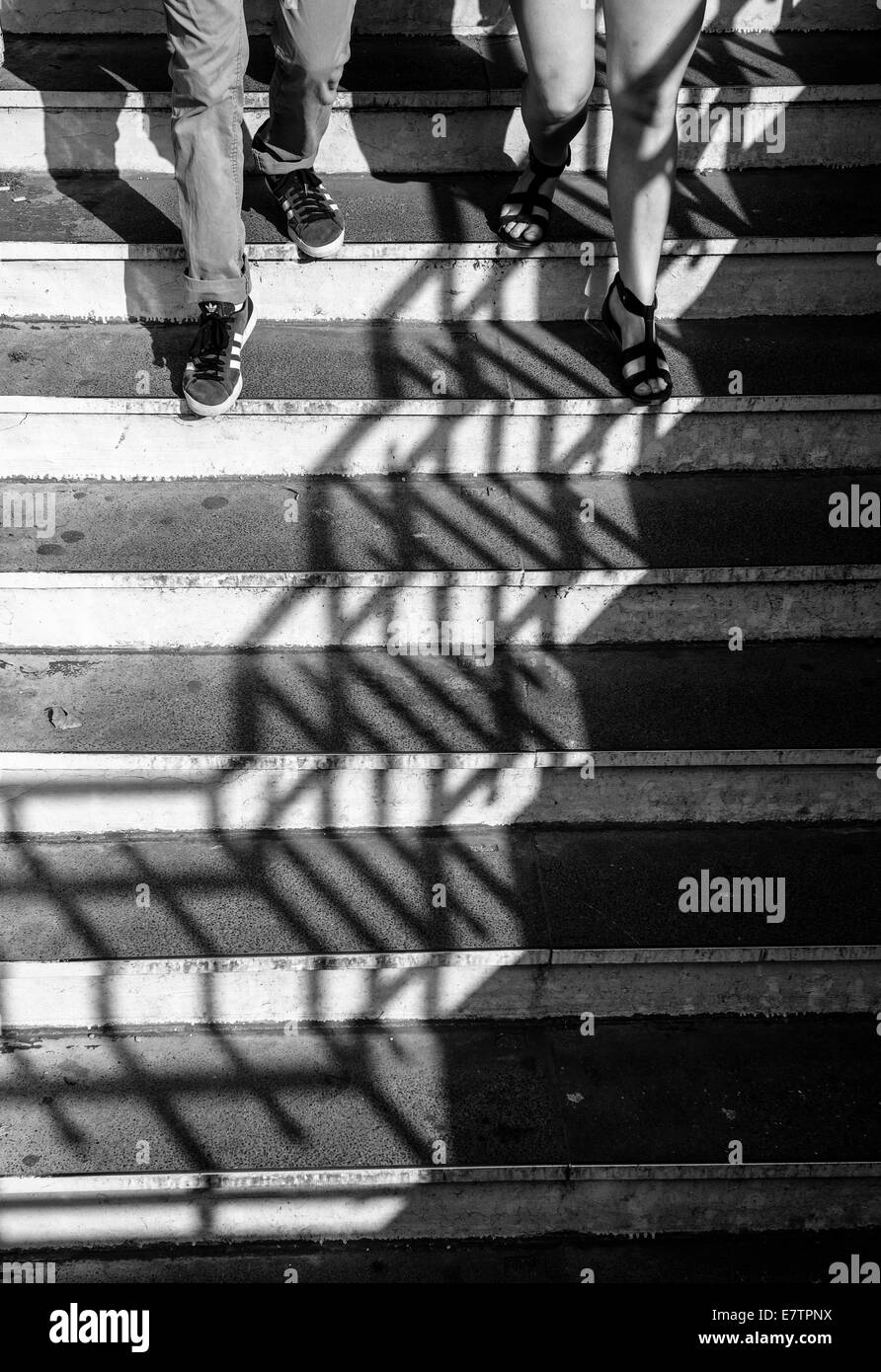 Shadows play as a couple descends a stairway Stock Photo