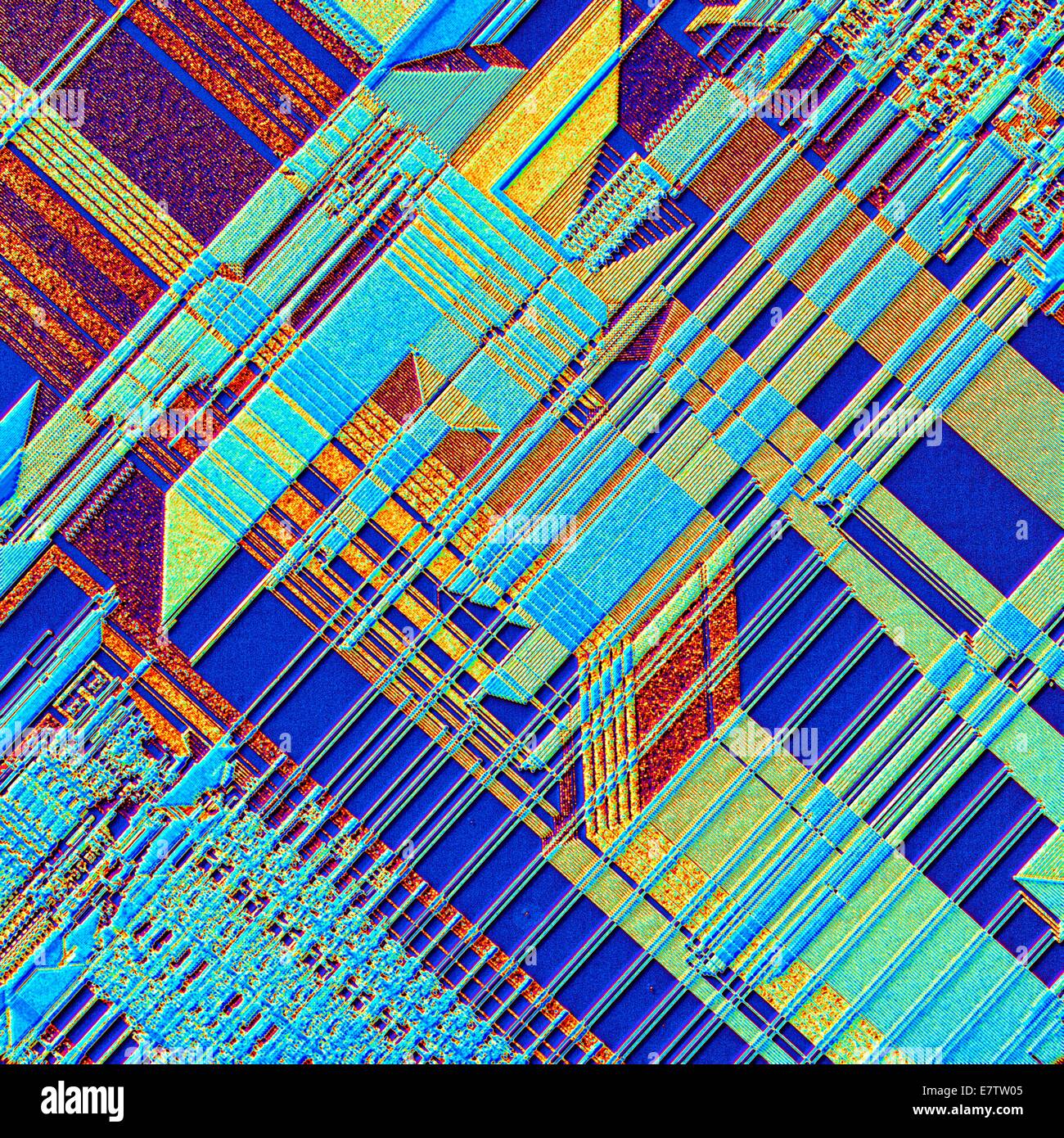 Computer chip. Coloured light micrograph of the surface of an integrated chip from a computer. This integrated circuit has been made by imprinting microscopic electronic components onto the surface of a wafer of silicon. Integrated circuits can be made mu Stock Photo