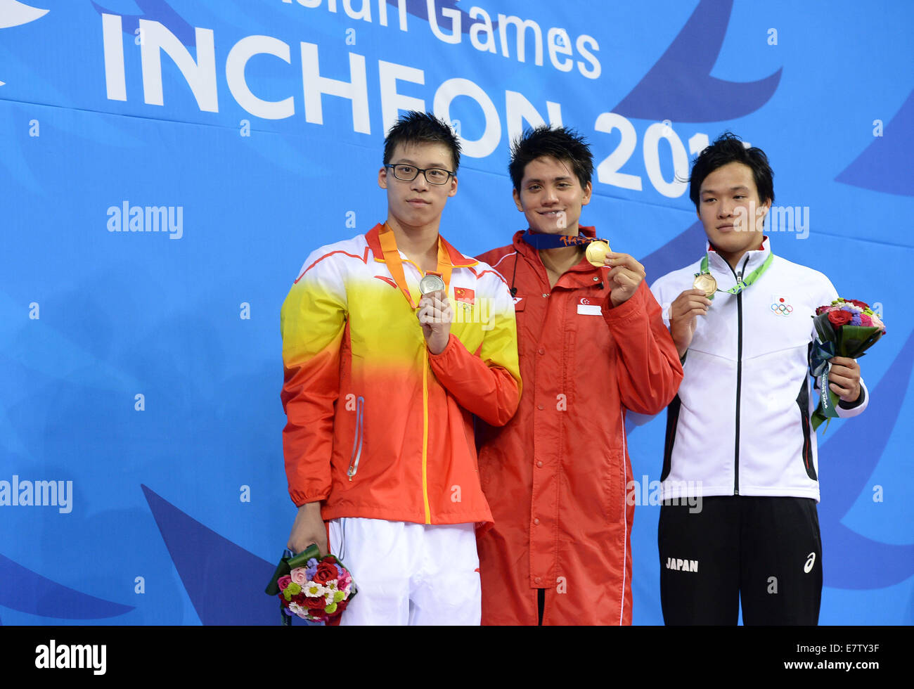 Incheon, South Korea. 24th Sep, 2014. Gold medalist Schooling Joseph Isaac (C) of Singapore, silver medalist Li Zhuhao (L) of China and bronze medalist Ikebata Hirofumi of Japan pose on the podium during the awarding ceremony of the men's 100m butterfly contest of swimming event at the 17th Asian Games in Incheon, South Korea, Sept. 24, 2014. Credit:  Wang Peng/Xinhua/Alamy Live News Stock Photo