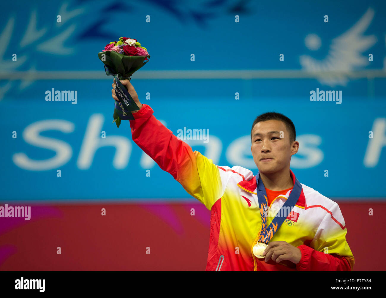 Incheon, South Korea. 24th Sep, 2014.Zhang Fuxiang of China poses on the podium during the awarding ceremony of men's sanda -56kg match of Wushu event at the 17th Asian Games in Incheon, South Korea, Sept. 24, 2014. Zhang Fuxiang defeated Bui Truong Giang of Vietnam and claimed the title. (Xinhua/Fei Maohua)(lz) Stock Photo