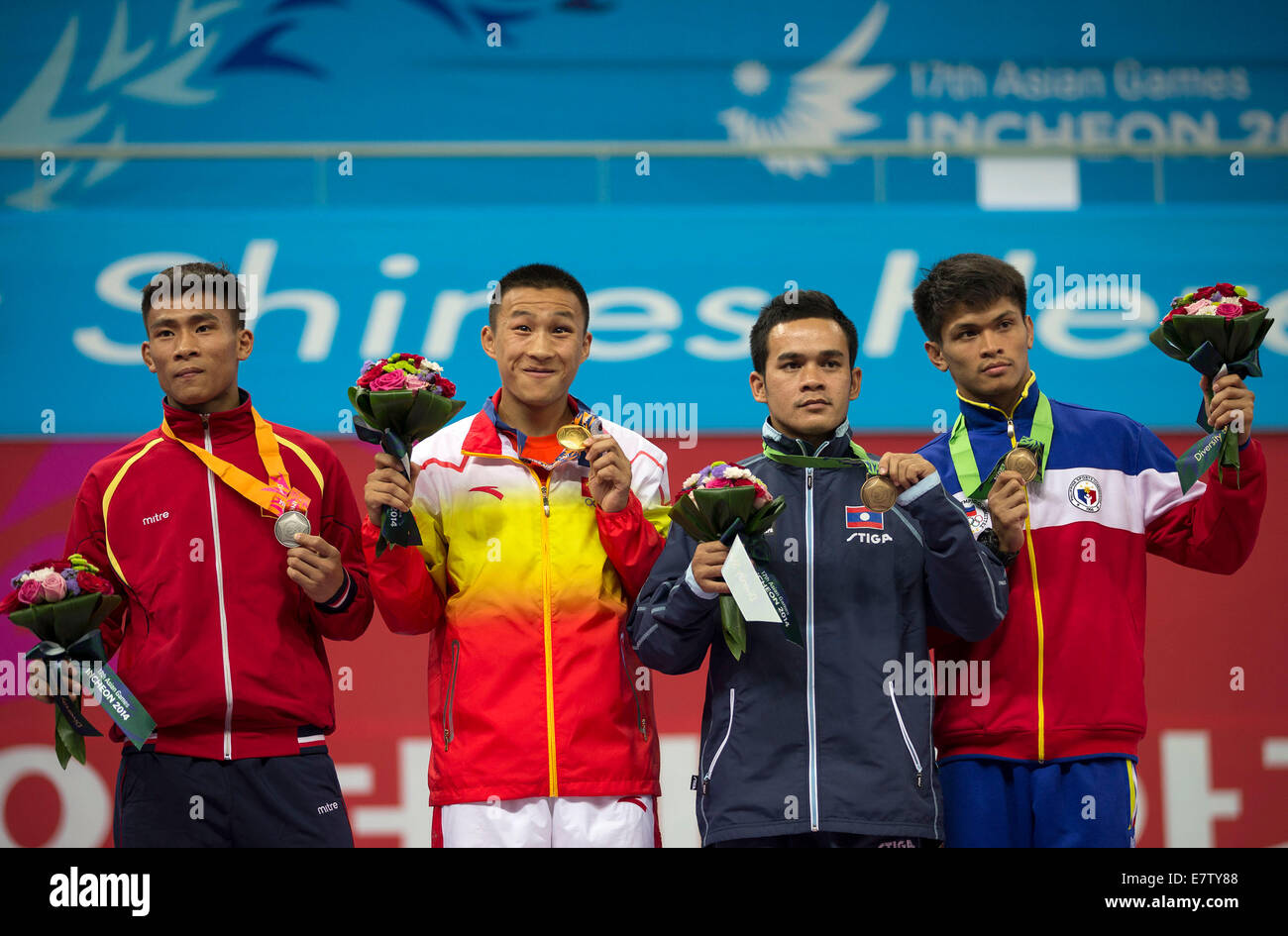 Incheon, South Korea. 24th Sep, 2014.Gold medalist Zhao Fuxiang (2nd L) of China, silver medalist Bui Truong Giang (1st L) of Vietnam, bronze medalist Soukaphone Khamla (2nd R) of Laos and Solis Franciso of Philippines pose on the podium during the awarding ceremony of men's sanda -56kg match of Wushu event at the 17th Asian Games in Incheon, South Korea, Sept. 24, 2014. (Xinhua/Fei Maohua)(lz) Stock Photo