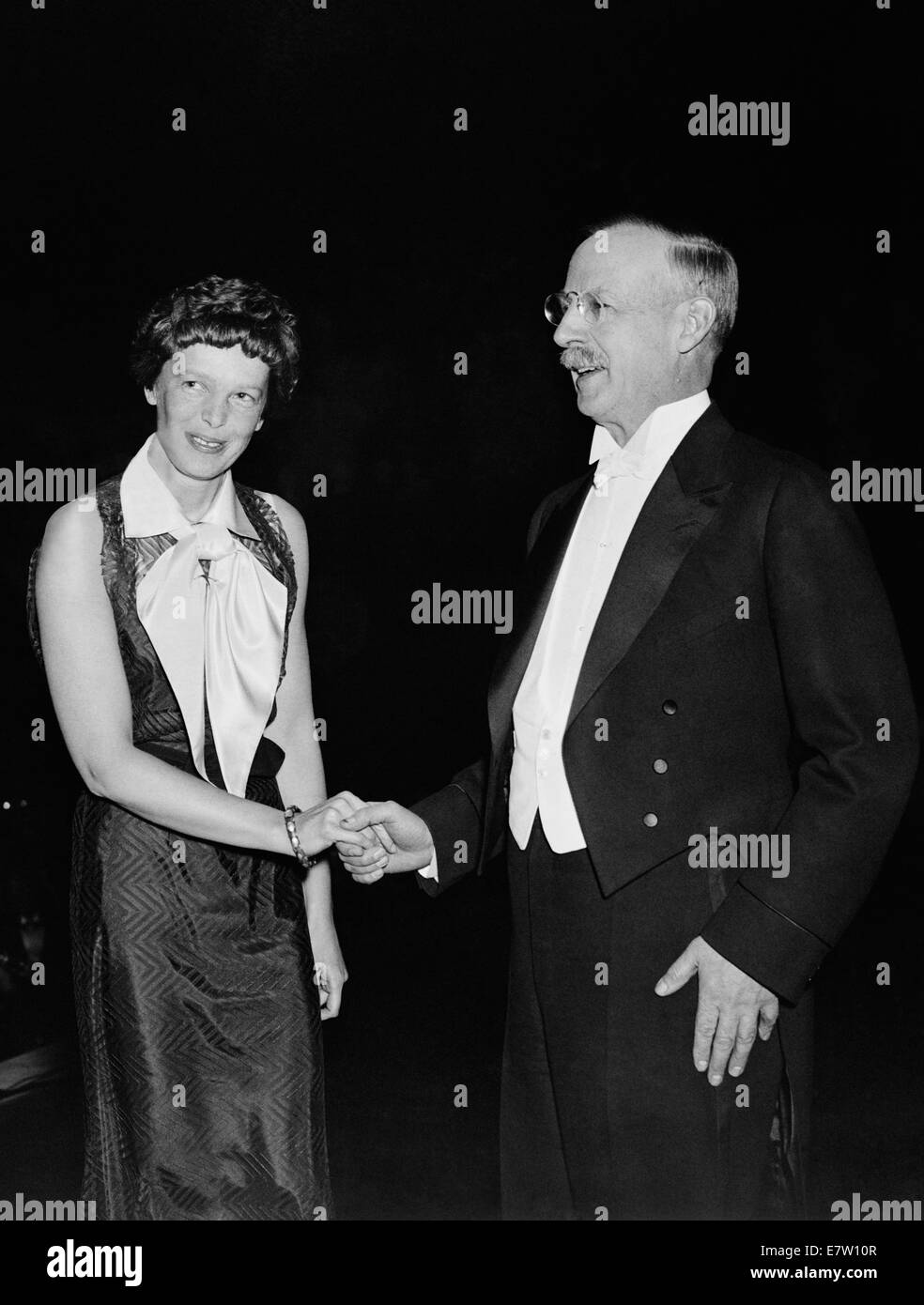 Vintage photo of American aviation pioneer and author Amelia Earhart (1897 – declared dead 1939) – Earhart and her navigator Fred Noonan famously vanished in 1937 while she was trying to become the first female to complete a circumnavigational flight of the globe. Earhart is pictured in 1935 with Gilbert Grosvenor, Editor of National Geographic magazine and President of the National Geographic Society. Stock Photo