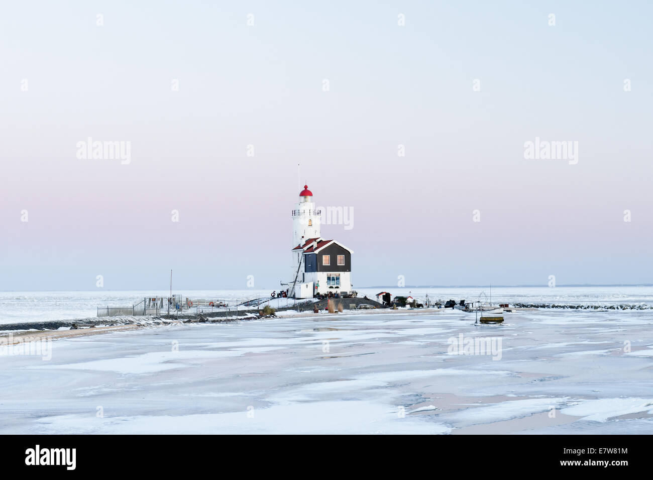 A frozen lake, reeds, and lighthouse in Holland Stock Photo