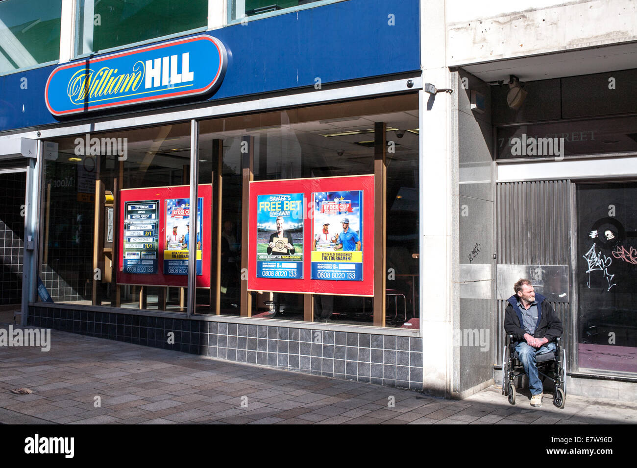 Disabled man in a wheelchair William Hill book makers in Sheffield South Yorkshire UK Stock Photo