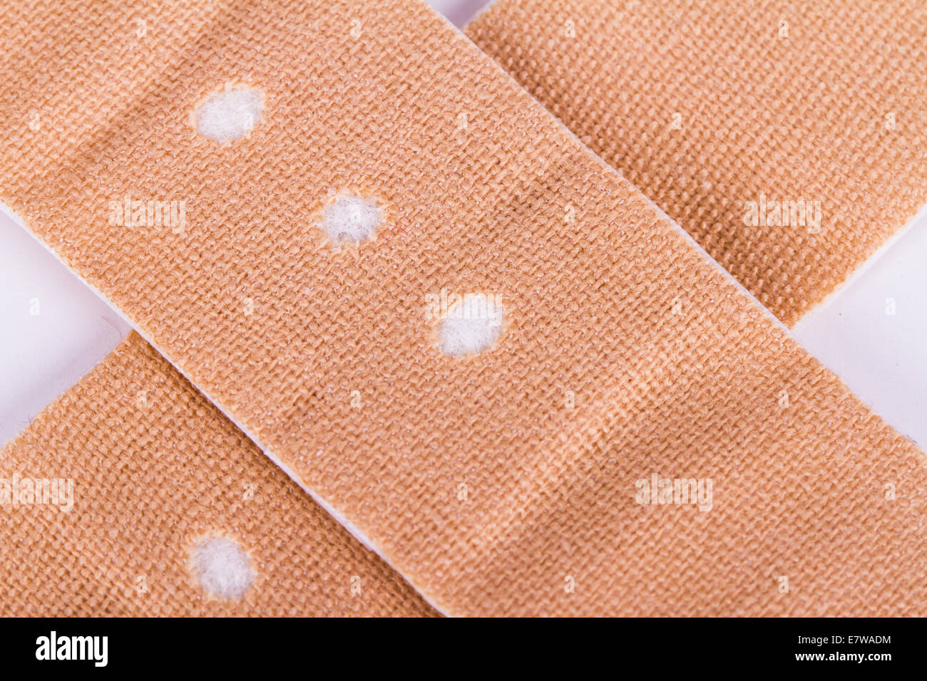 Close up view of adhesive bandage, plaster as cross sign, isolated on white background. Stock Photo