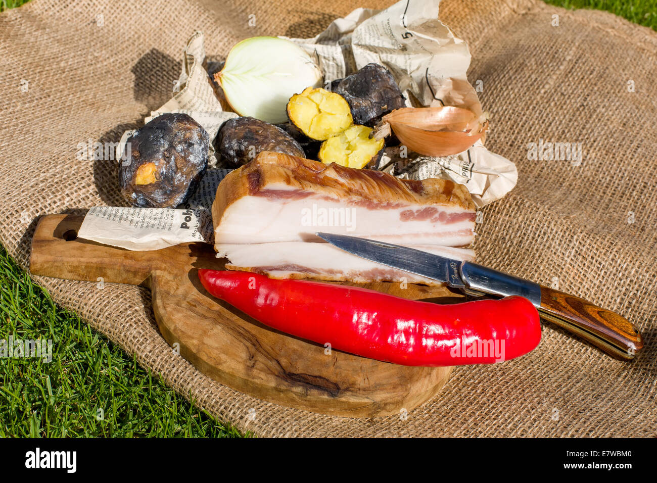 Farmers lunch - bacon, potatoes baked in the embers, peppers and onions Stock Photo