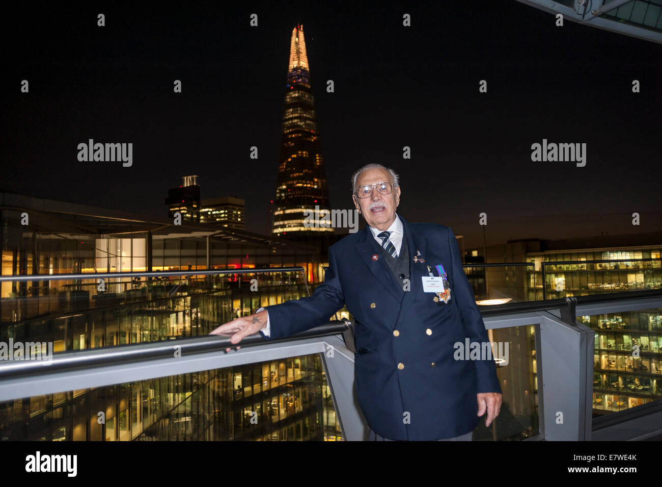 London, UK, 24 September 2014.  To mark the First World War Centenary and 75th anniversary of the start of the Second World War, the Mayor of London, Boris Johnson, commemorates the contribution of London-based veterans and military charities at a special community reception at City Hall.  Pictured: a veteran of the Suez conflict with his medals poses with the Shard as a backdrop.  Credit:  Stephen Chung/Alamy Live News Stock Photo