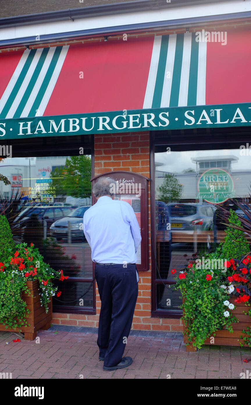 middle aged man reading menu outside a Hamburger Restaurant Stock Photo