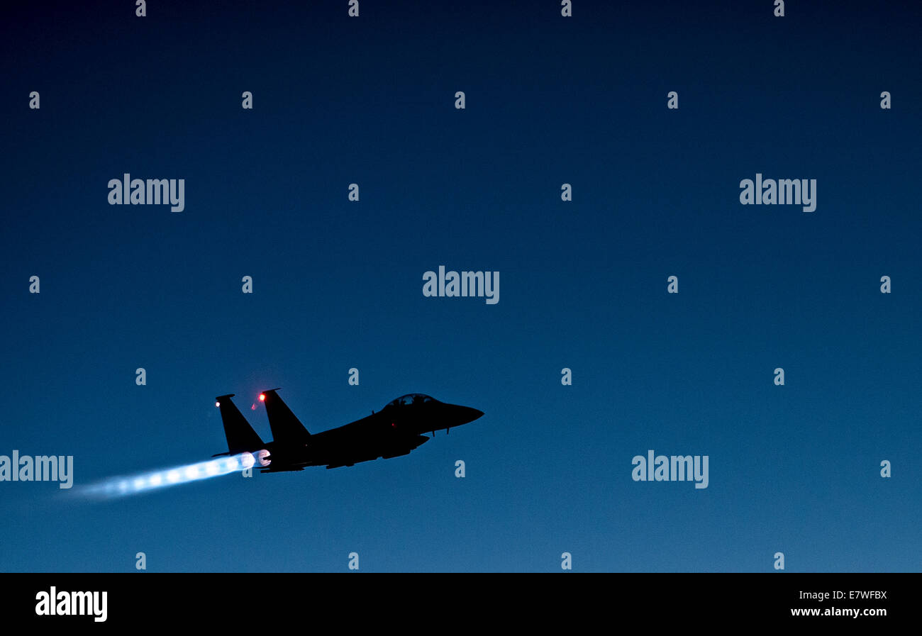 A US Air Force F-15E Strike Eagle fighter aircraft fires the afterburners as it flies over Iraqi airspace after completing combat sorties against ISIS targets in Syria September 23, 2014. The completed their first combat missions over Syria striking at ISIS targets. Stock Photo