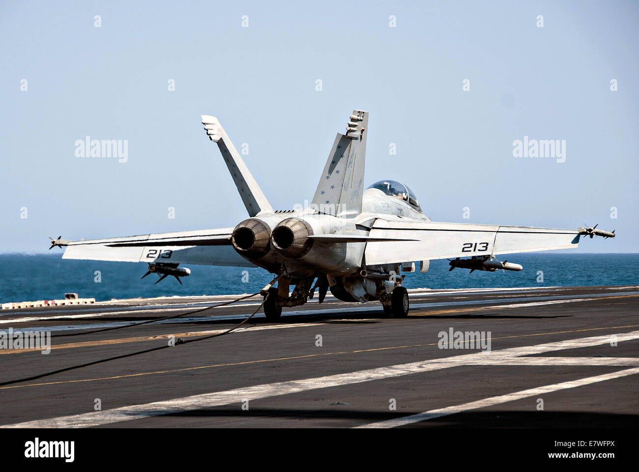 A US Navy F/A-18F Super Hornet fighter aircraft lands on the flight deck of the aircraft carrier USS George H.W. Bush after returning from a combat sortie against ISIS targets September 23, 2014 in the Persian Gulf. The military launched the first direct strikes on ISIS targets inside Syria. Stock Photo