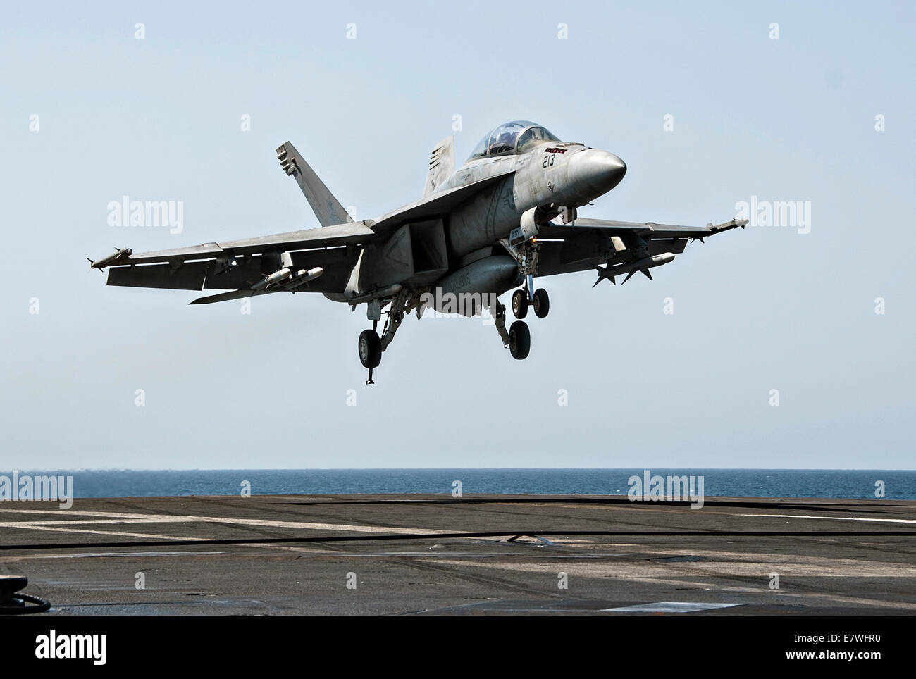 A US Navy F/A-18F Super Hornet fighter aircraft lands on the flight deck of the aircraft carrier USS George H.W. Bush after returning from a combat sortie against ISIS targets September 23, 2014 in the Persian Gulf. The military launched the first direct strikes on ISIS targets inside Syria. Stock Photo
