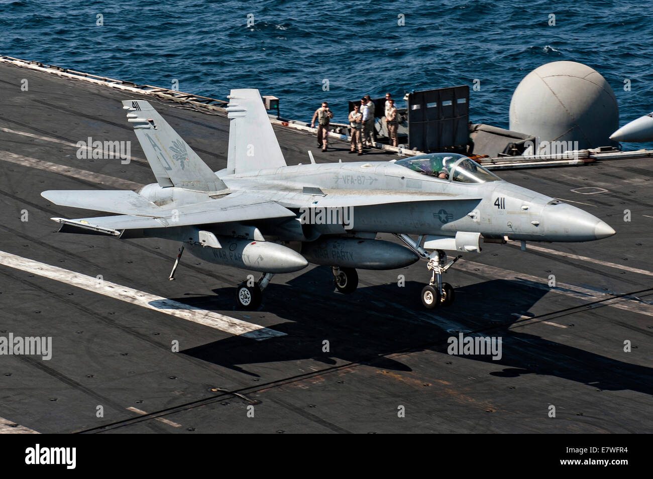 A US Navy F/A-18C Hornet fighter aircraft lands on the flight deck of the aircraft carrier USS George H.W. Bush after returning from a combat sortie against ISIS targets September 23, 2014 in the Persian Gulf. The military launched the first direct strikes on ISIS targets inside Syria. Stock Photo