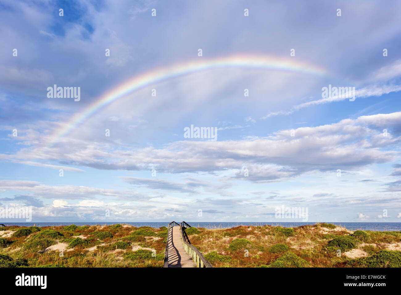Beautiful rainbow over  gorgeous sunlit sand dunes at the beach, Amelia Island, Florida. Stock Photo