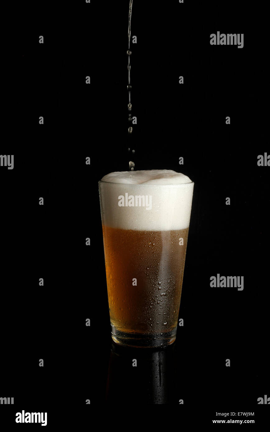 Overflowing beer glass Stock Photo