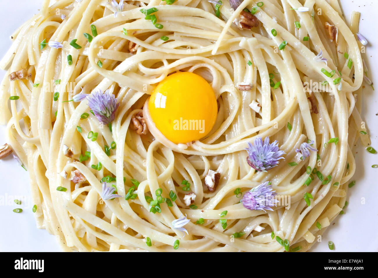 Plate of pasta with egg yolk in the center Stock Photo