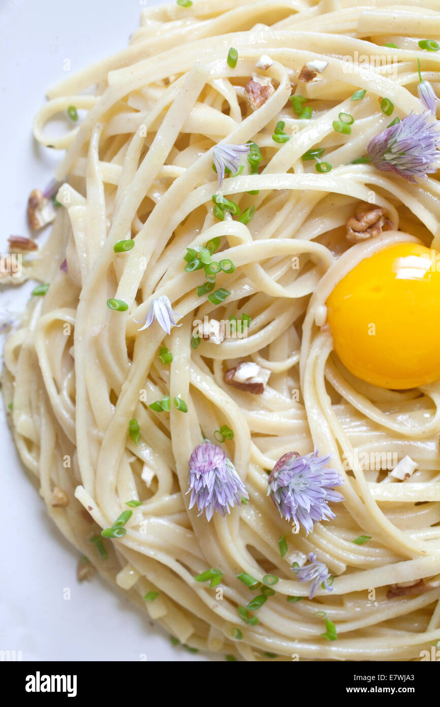 Plate of pasta with egg yolk in the center Stock Photo