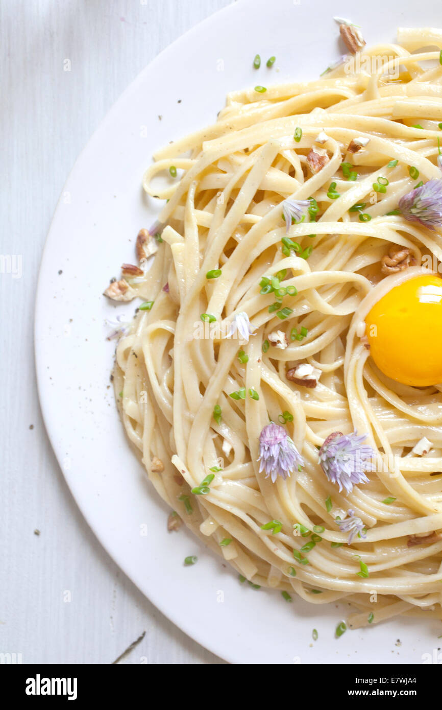 Plate of pasta with egg yolk in the center Stock Photo