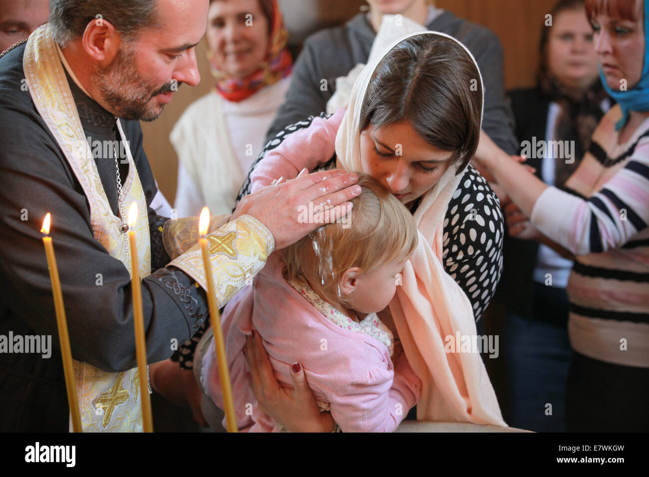 ST.PETERSBURG, RUSSIA - SEPTEMBER 21, 2014: Orthodox priest performs the rite of baptism for a little Russian girl Stock Photo
