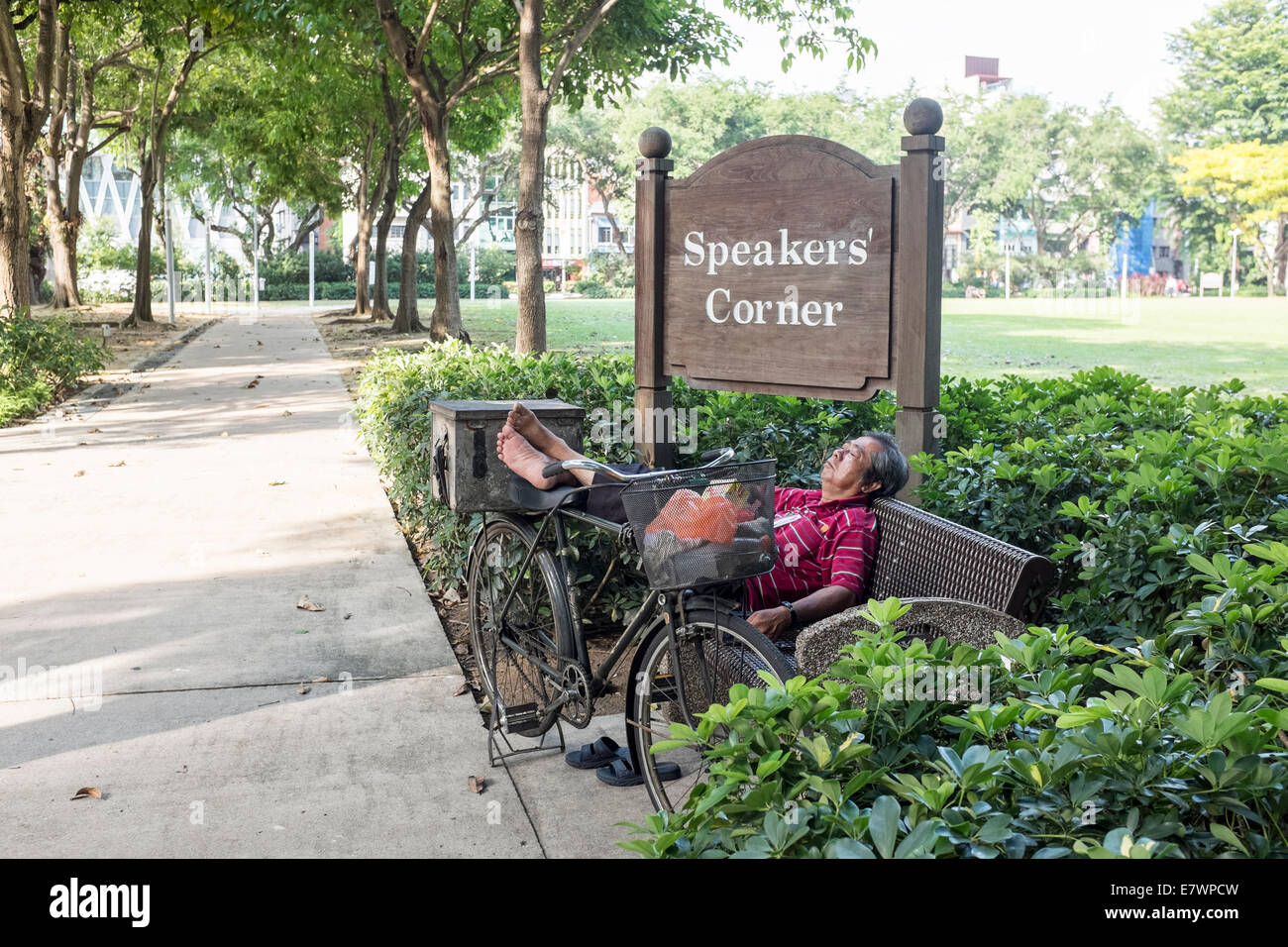 An elderly man takes a nap at the entrance to Speakers' Corner in Singapore Stock Photo
