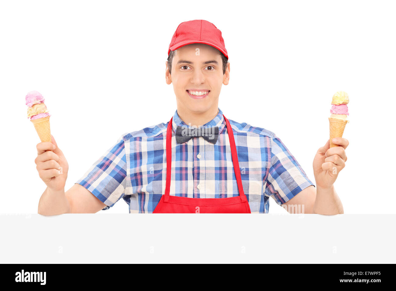 Male vendor holding two ice creams behind a panel isolated on white