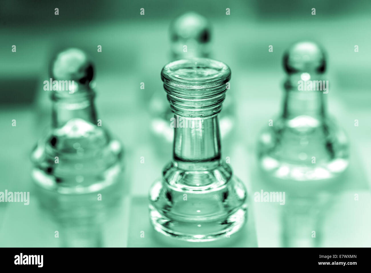 Rook chess piece with pawns in the background pieces made out of glass Stock Photo
